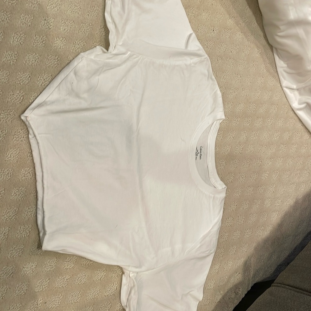 A white, short-sleeved t-shirt with a slightly frayed hem.